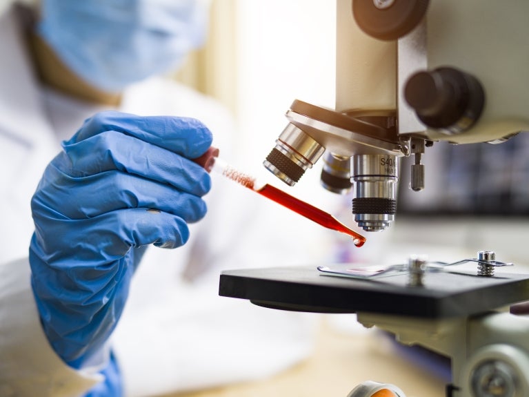 Healthcare image, doctor putting liquid under a microscope 